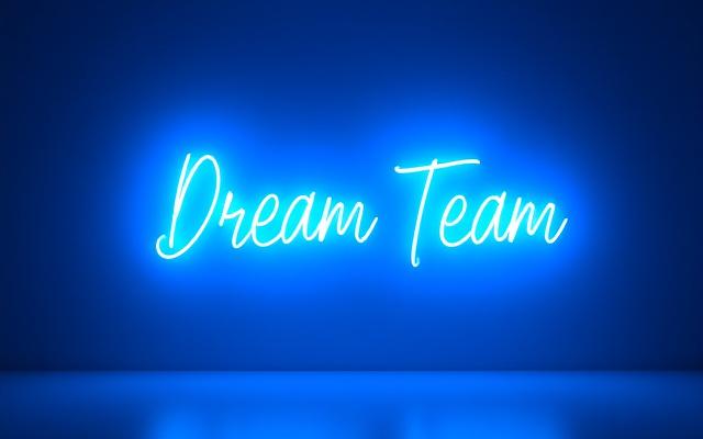 'Dream Team' neon sign in blue, against a corporate event backdrop, inspiring collaboration.